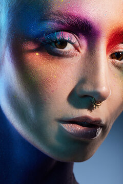 Colour Outside The Lines. Studio Shot Of A Young Woman Posing With Multi-coloured Paint On Her Face.