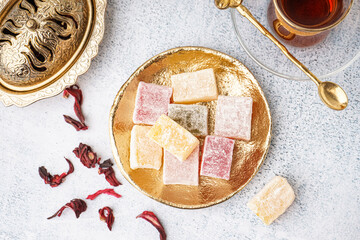 Plate with tasty Turkish Delight on light background