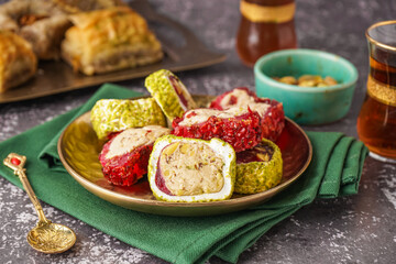 Plate with tasty Turkish Delight on grunge background
