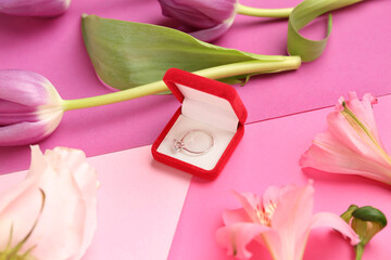 Obraz na płótnie Canvas Box with engagement ring and flowers on pink background, closeup