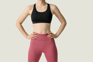 Sporty young woman in leggings on white background