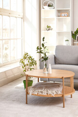 Vase with plant branches on coffee table in interior of bright living room