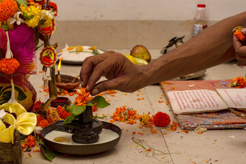 A hindu priests offering milk to Shiva linga on the occasion of an individual's first time entering...