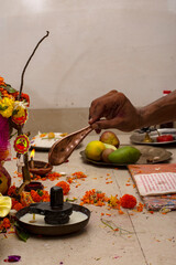 A hindu priests offering milk to Shiva linga on the occasion of an individual's first time entering their new home. Graha Pravesh entering the new home.