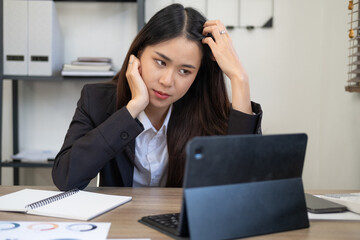 Young and beautiful businesswoman tired from work in the office.Woman holding her head