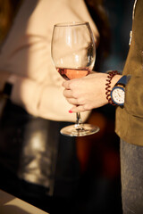 woman holding a glass of white wine in her hand. young woman holding a glass of white wine in her hands. woman holds a glass of wine, in her hand. the girl holds a glass of white wine in her hand.