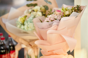 festive bouquet of flowers on the table. Glass vase with a bouquet of beautiful flowers on the table in the room. Place for text. Beautiful bouquet in a festive package on the table
