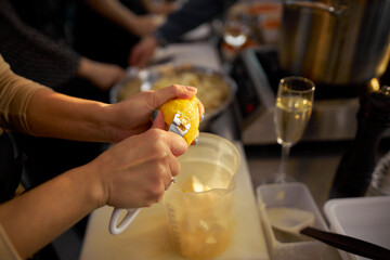 woman peeling the zest of an orange, close-up. Closeup of woman rubbing orange zest on grater. Orange zest with a grater.
