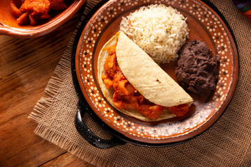 Pork rinds in red sauce Taco accompanied by rice and refried beans. Traditional homemade dish very popular in Mexico, this dish is part of the popular Tacos de Guisado.