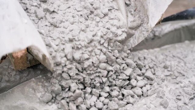 Concrete mortar with stone is poured into foundation formwork, close-up