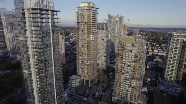 Aerial pan around residential towers revealing city transit centre during an evening in Vancouver, BC