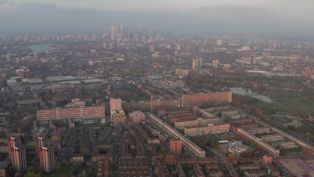 Aerial slider shot over south London council estates looking towards Canary Wharf