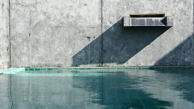 4K water wave with faucet of swimming pool on cement wall, construction industry