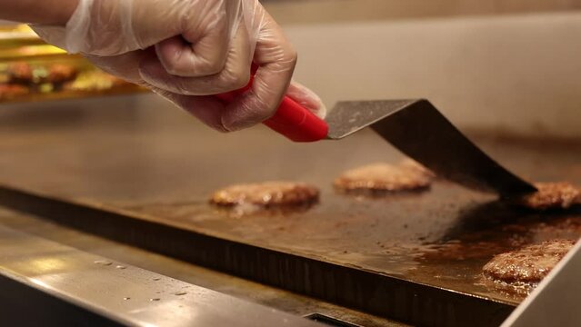 Chef Cooking Burger Meat Using Metal Spatula.