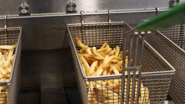 French Fries Cooling Off In Fryer Baskets.