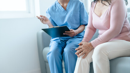 Naklejka premium Asian Chinese female physiotherapist caregiver helping elderly woman exercise for recovery, prevention of osteoarthritis and osteoporosis.