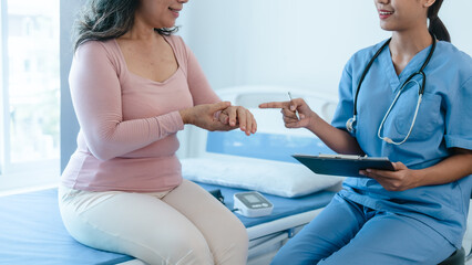 Fototapeta premium Asian Chinese female physiotherapist caregiver helping elderly woman exercise for recovery, prevention of osteoarthritis and osteoporosis.