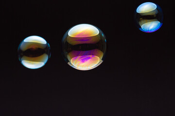 wonderfully shimmering soap bubbles floating in the air in front of a black background
