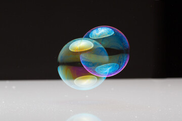 wonderfully shimmering soap bubbles floating in the air in front of a black background