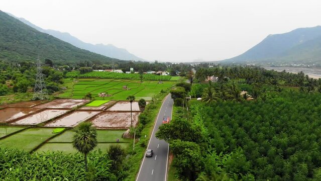 Drone shot of a truck driving through Tamil Nadu surrounded with beautiful nature, near Vellore, India