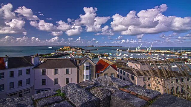 Panning time lapse shot over a busy harbor on the sea of the Channel Island of Guernsey.
