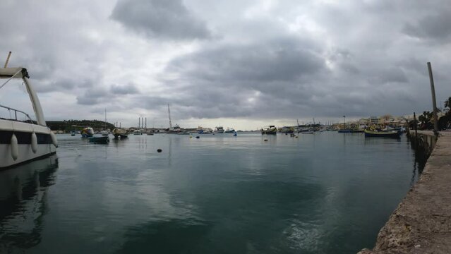 Timelapse at Marsaxlokk harbour. Nice boats movement during a cloudy day