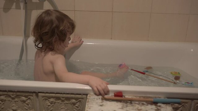 A little boy is taking a bath
