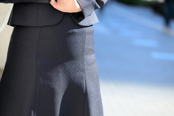 屋外で立ち止まってスマホを操作しているビジネスウーマン	