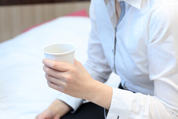 Fototapeta na wymiar 仕事中にコーヒーを飲んで休憩している女性　ノートパソコン　ビジネス