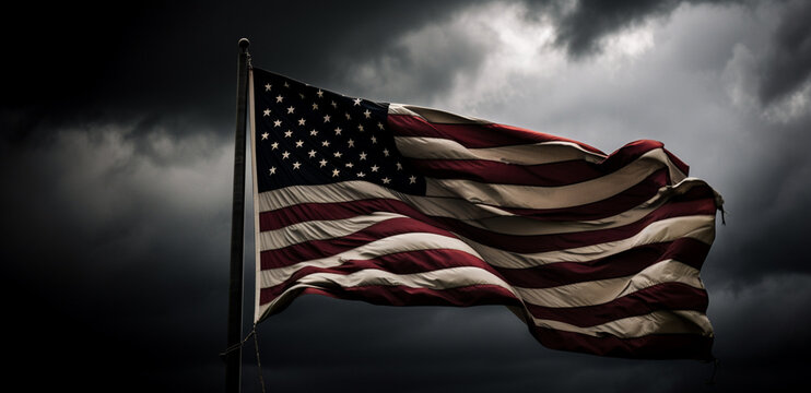 A close-up image of the American flag blowing in the wind with a dark and dramatic sky in the background