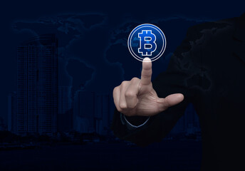 Businessman pressing bitcoin icon over world map, modern city tower and skyscraper, Choosing bitcoin concept, Elements of this image furnished by NASA