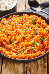 Turkish style bulgur pilaf is a classic hearty and healthy side dish close-up in a bowl on a wooden table. Vertical