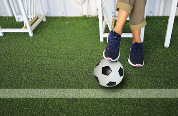 Obraz premium woman foot step on football beside the grass field represent to she is a team manager.