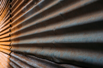 Wavy gray metal profiles of gray color with rust, abstract industrial background, low quality building materials