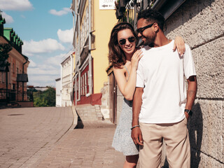 Smiling beautiful woman and her handsome boyfriend. Woman in casual summer clothes. Happy cheerful family. Female having fun. Sexy couple posing in the street at sunny day. In sunglasses