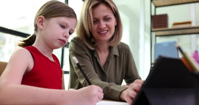 Little girl studying with teacher using tablet at home 4k movie slow motion. Tutoring services preparation for school concept