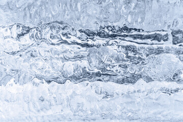 Blue ice and icicles on the rocks of frozen waterfall. Great natural background with copy space for your design.