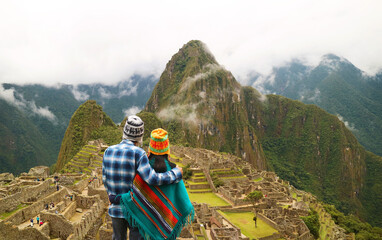 Couple being impressed with the incredible view of Machu Picchu ancient Inca citadel, UNESCO world...