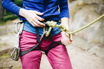Close up shot of a man's hands holding a rock climbing belaying device