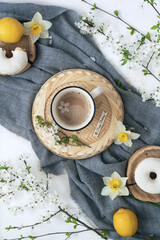 A cup of warm, warming aromatic tea, coffee, flowers nearby