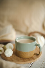 Fototapeta na wymiar A cup of warm, warming aromatic tea, coffee, flowers nearby