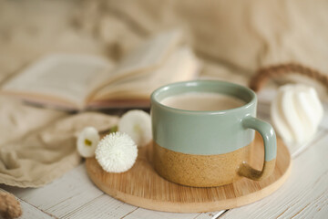 A cup of warm, warming aromatic tea, coffee, flowers nearby