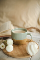 Fototapeta na wymiar A cup of warm, warming aromatic tea, coffee, flowers nearby