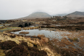 Sligachan old Bridge, Isle Of Skye, Scotland. Sligachan bridge during sunset and a partly cloudy sky, the water flows quickly under the bridge. Foogy day on Isle of Skye.