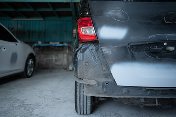 A car mechanic checks the condition of a car body to be repaired after a collision. by marking the...