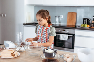 tiramisu making process in the kitchen- little girl making Italian desert with cocoa and espresso-dipped ladyfingers with mascarpone cream (step by step)