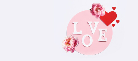 The word love made of paper letters, red hearts and natural roses on a white background. Banner, Flat lay, top view, copy space.