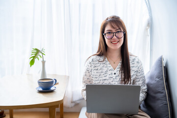 asian freelance people business female wearing smartwatch talking making using casual working with laptop computer for browsing internet, chatting and blogging and smartphone,notebook in coffee shop.