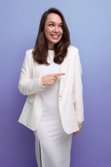 Fototapeta premium close-up portrait of a smiling european brunette woman with long hair in a white dress and jacket posing on a studio background