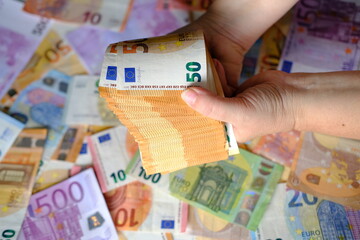 closeup female hands count paper 50 euro banknotes of european union, paper banknotes on table,...